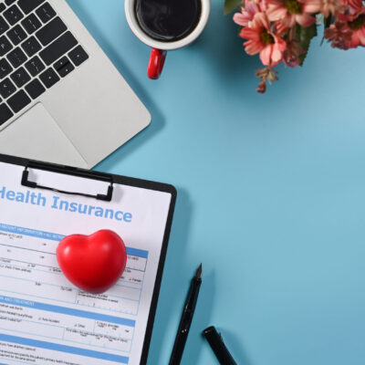 flat-lay-health-insurance-claim-form-and-heart-on-blue-desk
