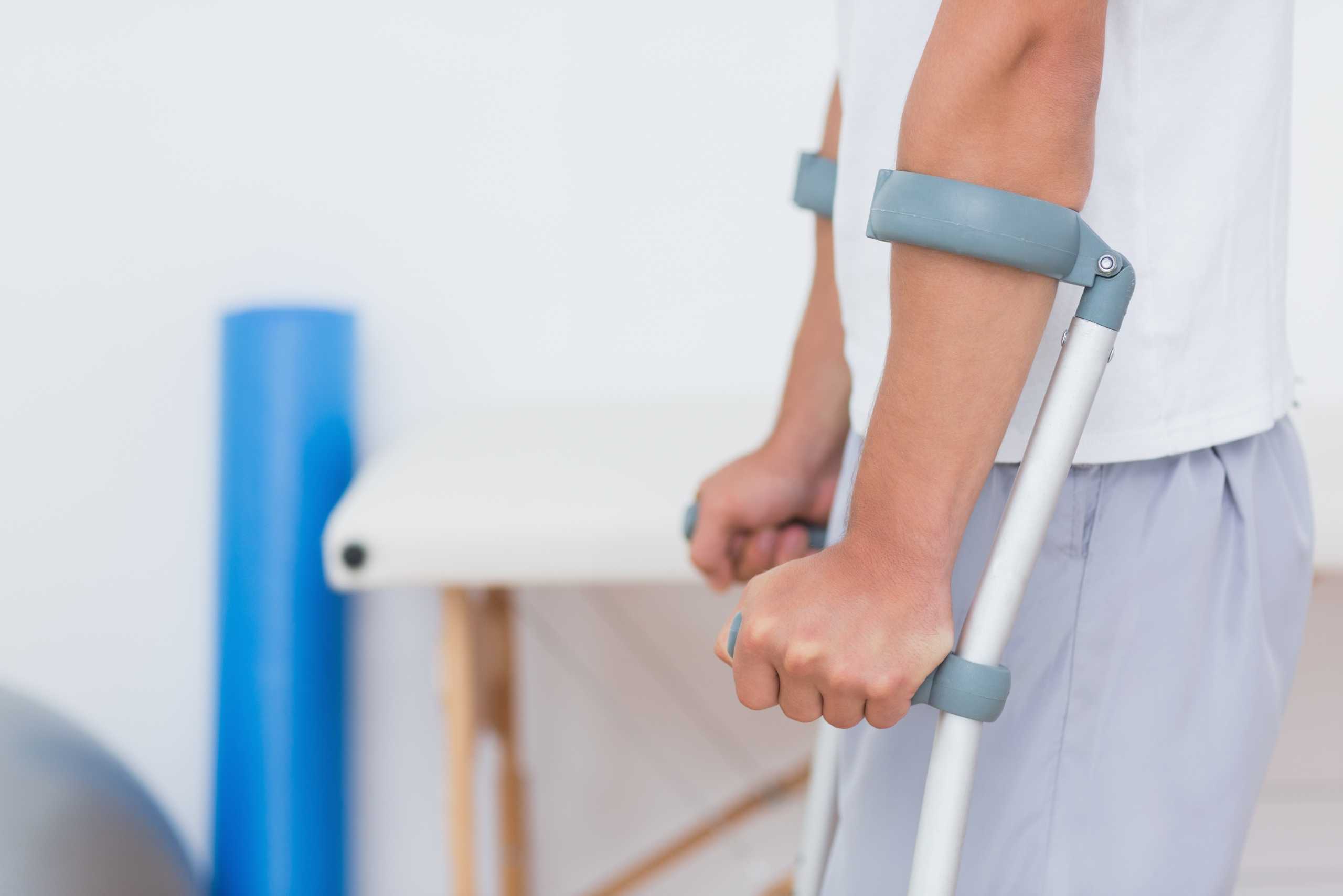 patient-standing-with-crutch-medical-office